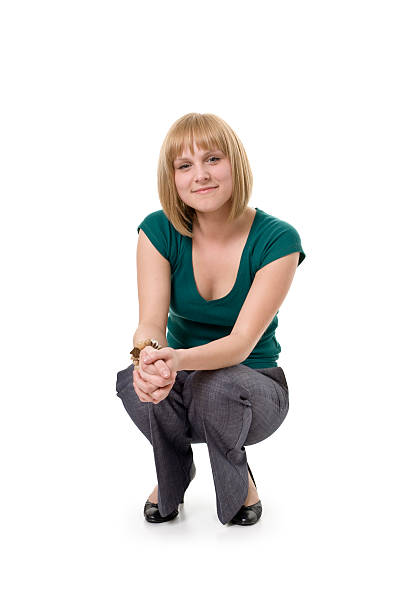 teenage girl with long red hair is relaxing in chair with her bare feet up looking at the camera.