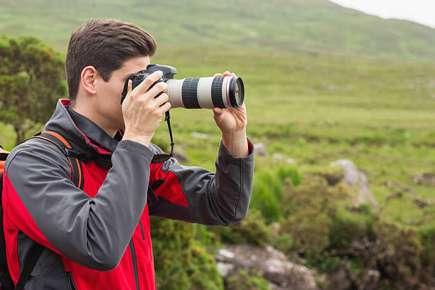 istock Handsome man on hike taking a photograph 471089824