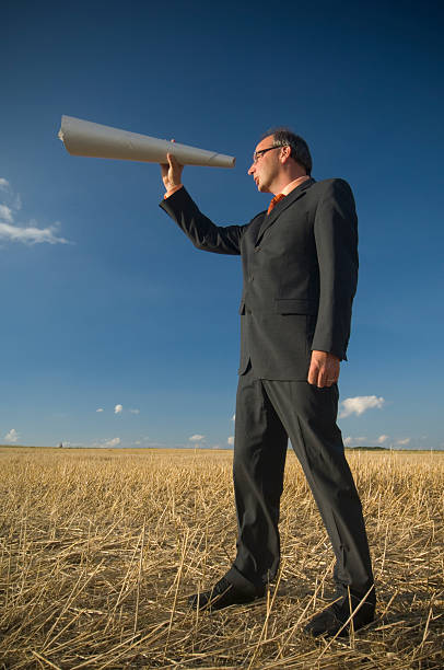 istock Businessman looking through a telescope 471089869