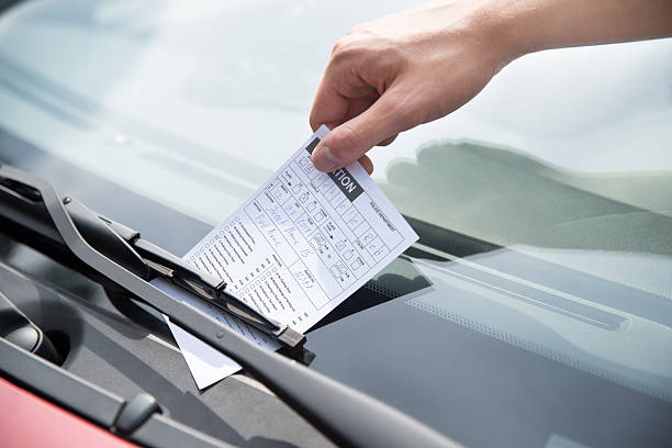 istock Officer's Hand Putting Parking Ticket On Car 471089924