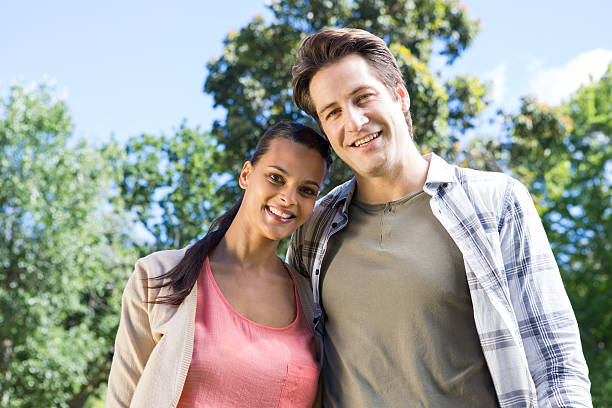 istock Happy couple smiling at camera in park 471090034