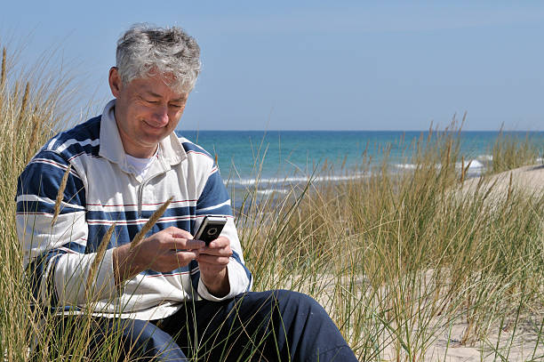 e メールのチェック、携帯電話 - mobility e mail vacations beach ストックフォトと画像
