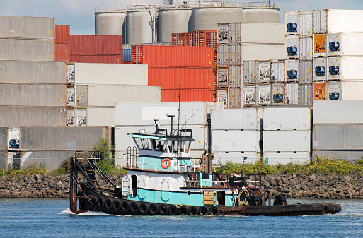 Tugboat and containers on industrial waterway