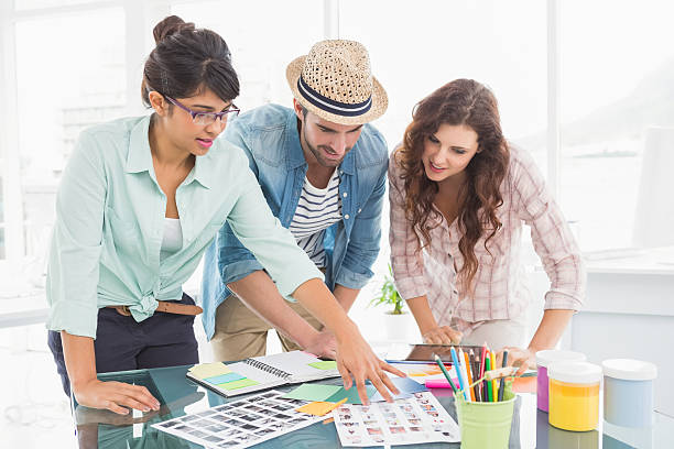 istock Smiling coworkers editing photos together 471092818