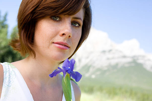 Bella giovane donna con fiori in montagna - foto stock