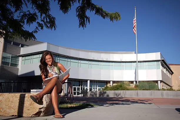 Photo of Teenage Student in Front of School