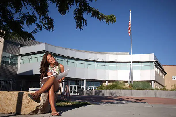 Photo of Teenage Student in Front of School