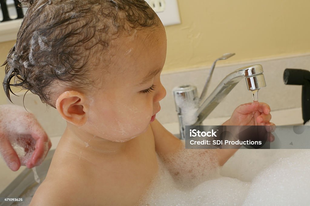 Playing with Faucet Water A toddler playing while getting a bath. 12-17 Months Stock Photo