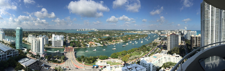 Panoramic view of city. Cityscape is against sky. Image is representing development. Boats are sailing on river.