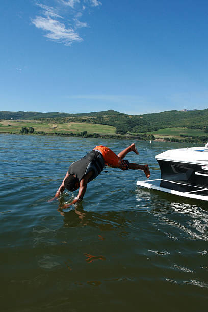 cara saltou de barco - life jacket child black sailing - fotografias e filmes do acervo