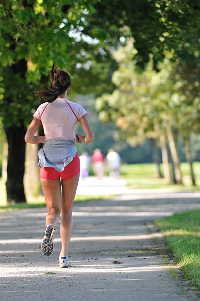 istock Young Woman jogging 471094639