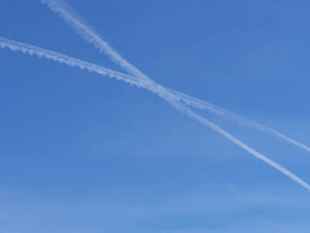 istock Two airplane con trails cross in the blue sky 471095516