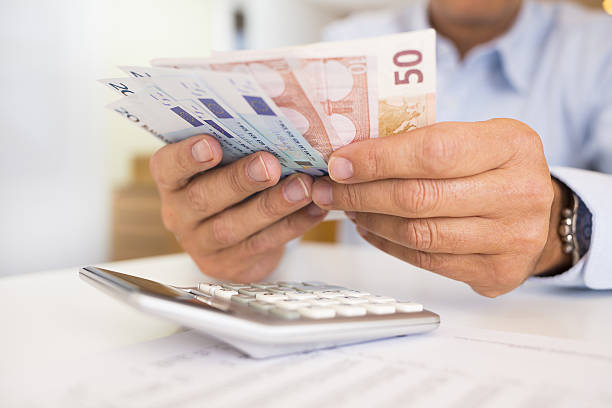 istock A man counting paper bills with a calculator 471095650