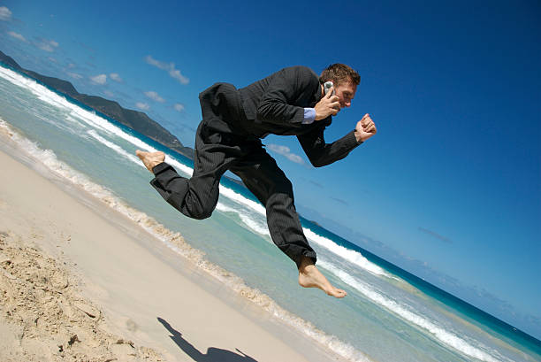 istock Businessman Beach Leap Phone 471096021