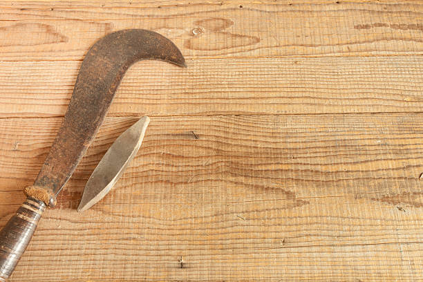 dated and used billhooks on wooden background