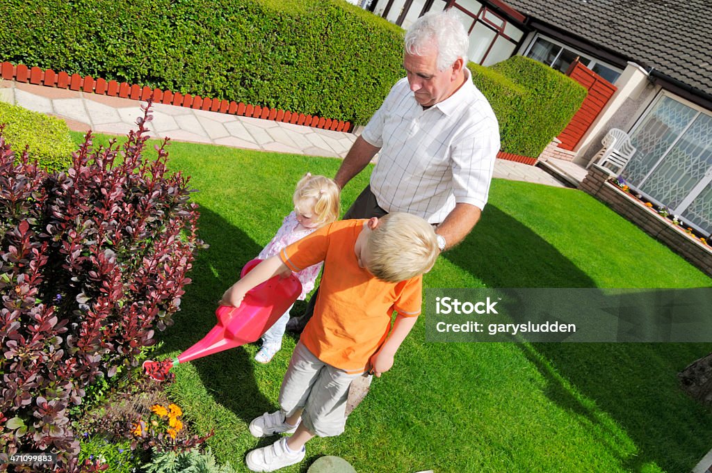 grandafather Работать в саду с его двух внуков - Стоковые фото Дедушка роялти-фри