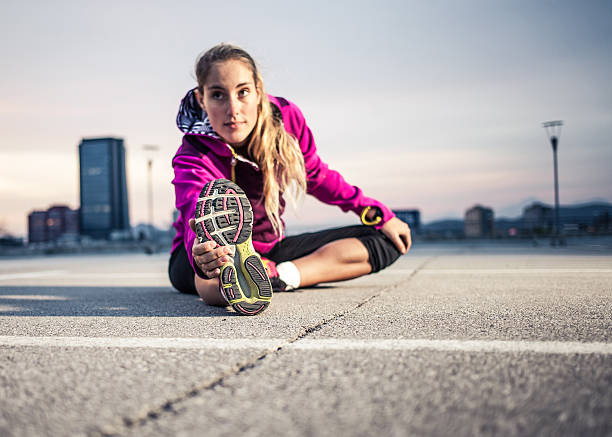 istock Athletic woman stretching at an outdoor pavement 471101128