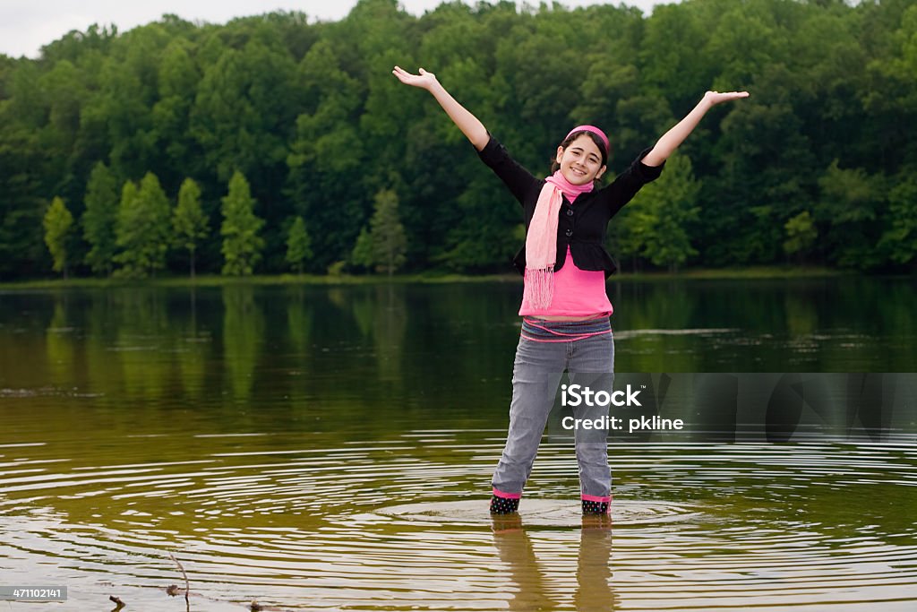 Teen girl standing in superficiales de un lago de agua - Foto de stock de 14-15 años libre de derechos