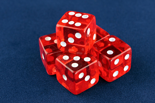 Stack of 5 dice showing all numbers on a blue velvet table top