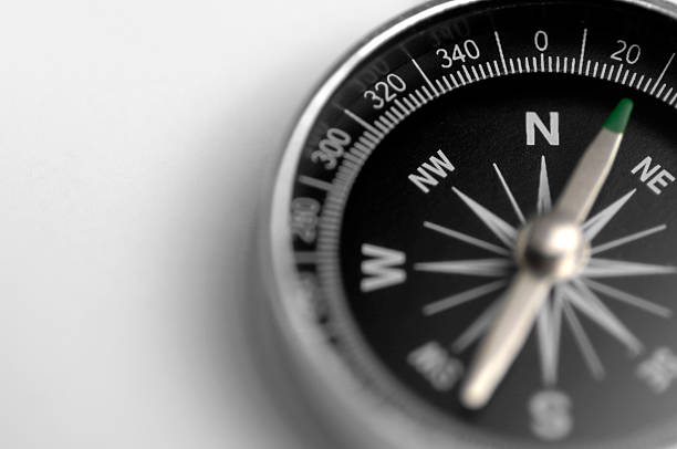 A black and silver compass on a white background macro selective focus image of compass navigational compass photos stock pictures, royalty-free photos & images