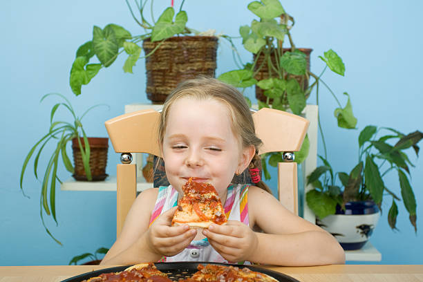 istock Girl eating pizza 471103691