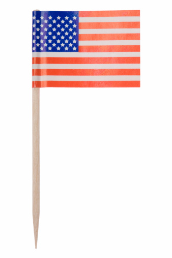 One of those tiny flags on a toothpick. This one is the American flag. Isolated on a pure white background.  