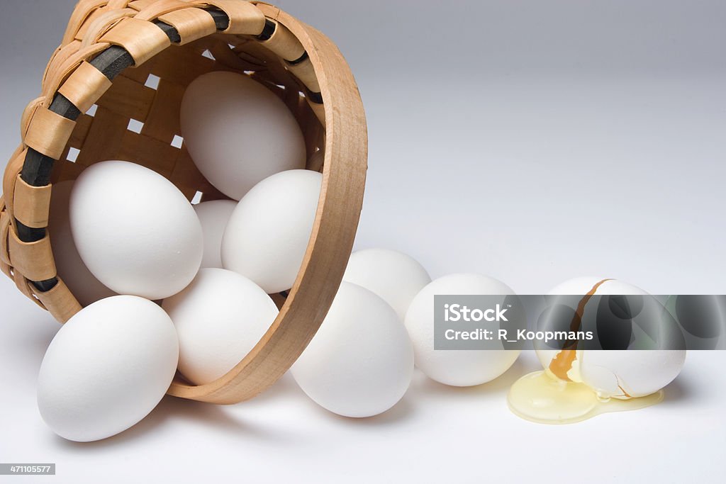 Broken egg from a spilled basket A version of the old cliche warning of eggs in one basket. Egg - Food Stock Photo