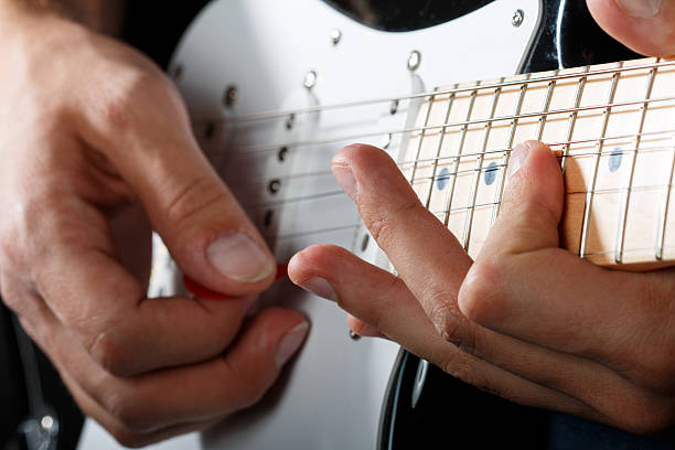 istock Hands of man playing electric guitar closeup 471106384