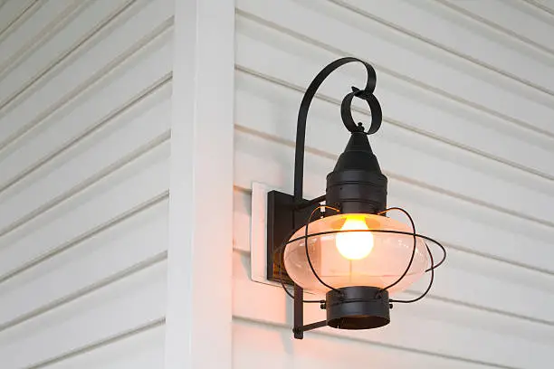 Subject: An old fashion sconce on a clapboard wall