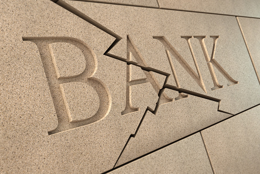 High quality 3d rendering of a sandstone 'BANK' sign breaking up with cracks