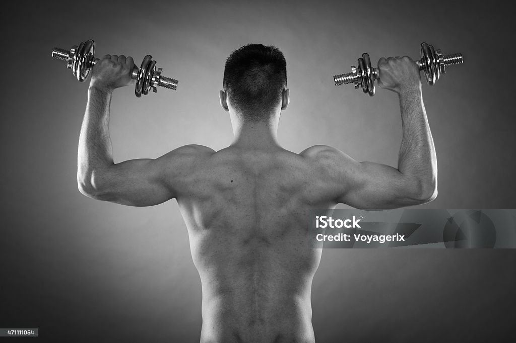 Atletica uomo lavorando con manubri pesanti - Foto stock royalty-free di 2015