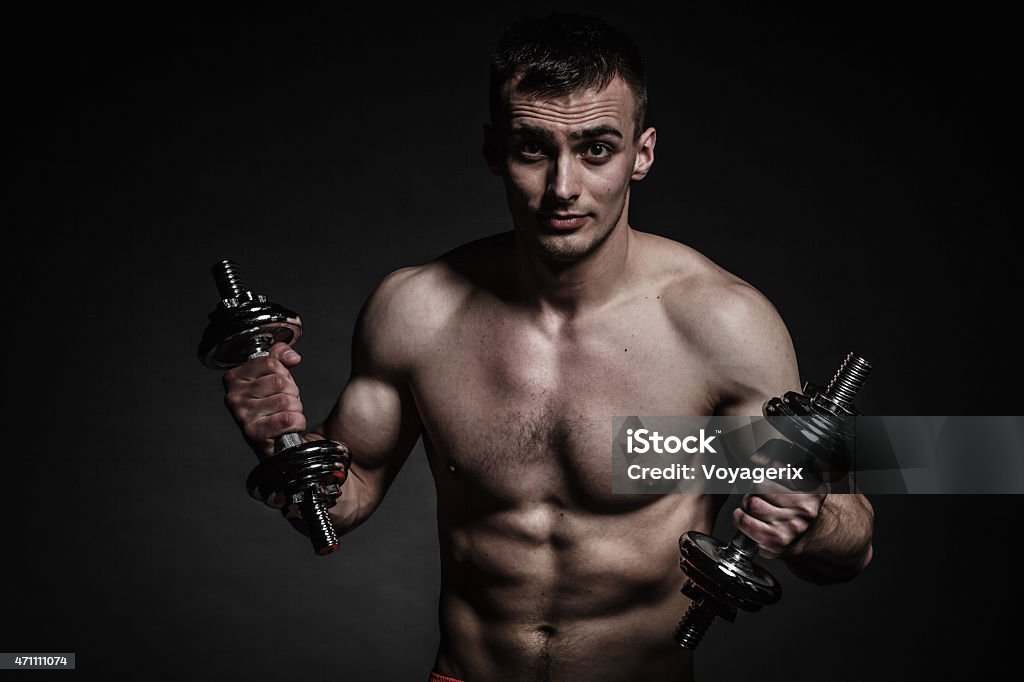 Atletica uomo lavorando con manubri pesanti - Foto stock royalty-free di 2015