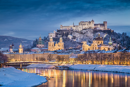Beautiful view of the historic city of Salzburg with Salzach river in winter during blue hour, Salzburger Land, Austria.