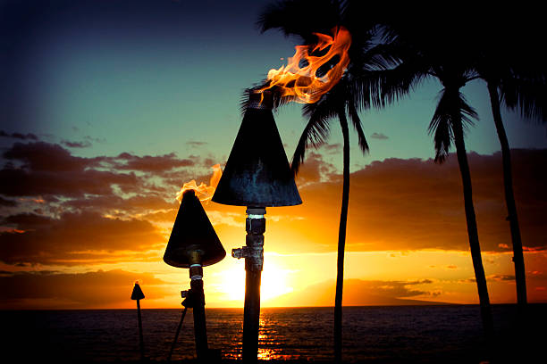 Fire torches against a beautiful island sunset A beautiful island sunset. tiki torch stock pictures, royalty-free photos & images