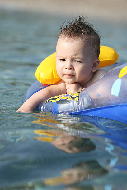 serious baby boy in the sea stock photo