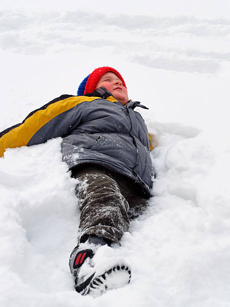 istock Child making snow angels and enjoying winter day 471112633