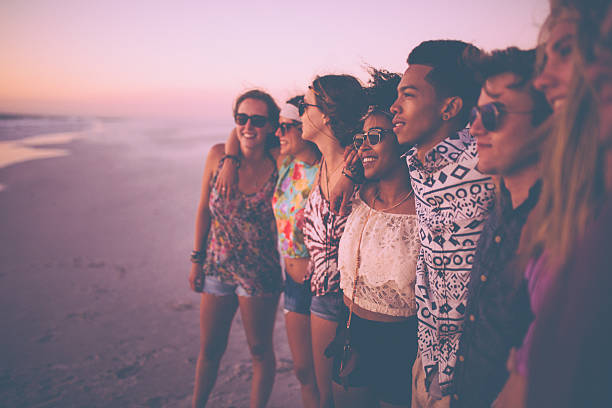 istock Mixed race group of friends watching a beach sunset together 471113334
