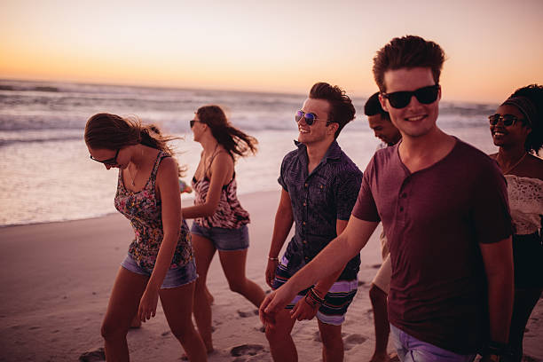istock Young friends walking on a beach after sunset 471113338