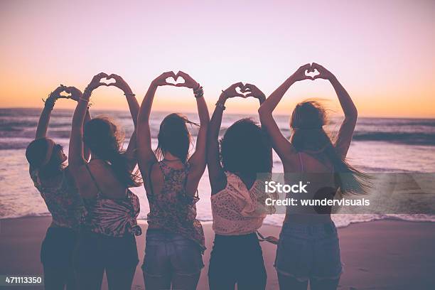 Silhouette Of Girls Making Heart Shapes With Their Hands Stock Photo - Download Image Now