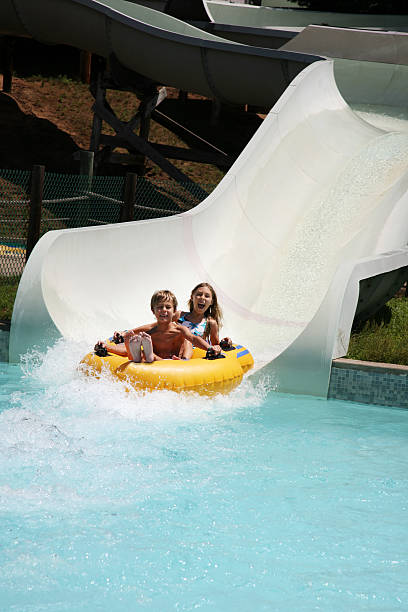 crianças no toboágua no parque de diversões - inflatable slide sliding child - fotografias e filmes do acervo