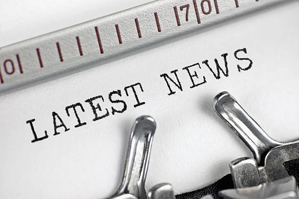 A yellow typewriter with a piece of paper labeled news sits on a desk. Jounalism, newspaper concept