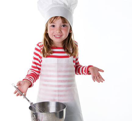 An adorable little girl with an apron and chef hat is making a gesture as if to say \