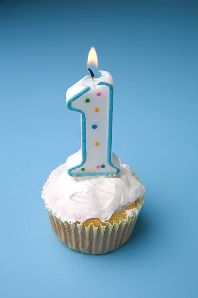 istock A cupcake with a 1 candle against blue background 471117489