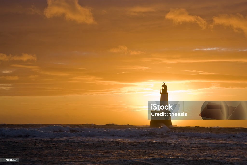 North Sea Lighthouse With Rising Sun The lighthouse at Rattray Head near Peterhead, northeast Scotland. Beach Stock Photo