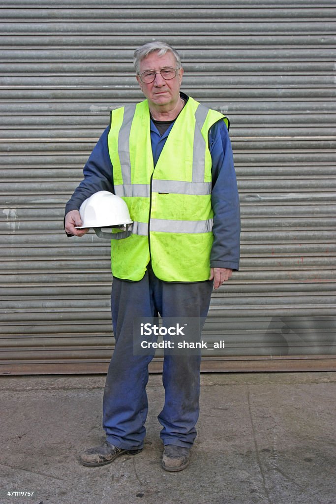 construction worker experienced skilled worker in high visability jacket and holding a white hard hat. Adult Stock Photo