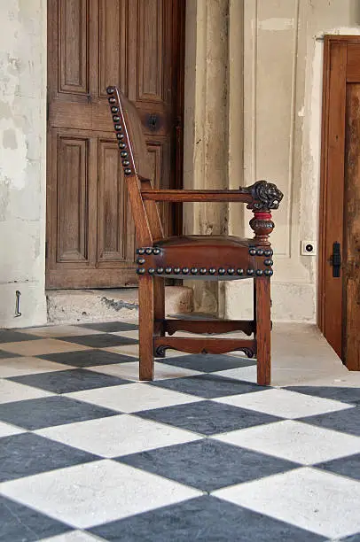 Château de Chenonceau hall with chair on tiled floor.