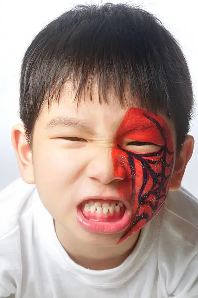 A young boy showing angry painted face.