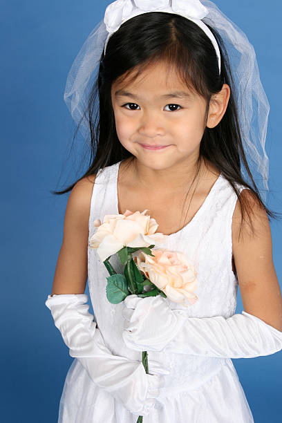 Five year old little girl dressed up as bride for wedding