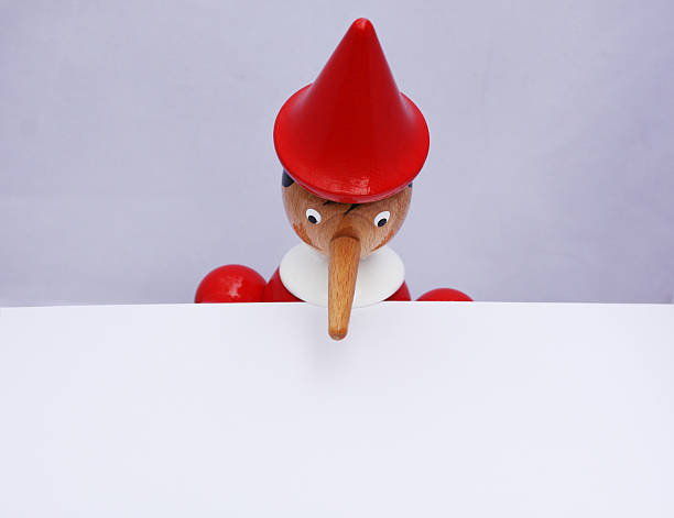 Pinocchio Pinocchio looking down onto a blank sheet of paper. Shallow depth of field with focus on his face. Plenty of room for copy. This file is available as an illustration (vector file) in my portfolio. bluff stock pictures, royalty-free photos & images