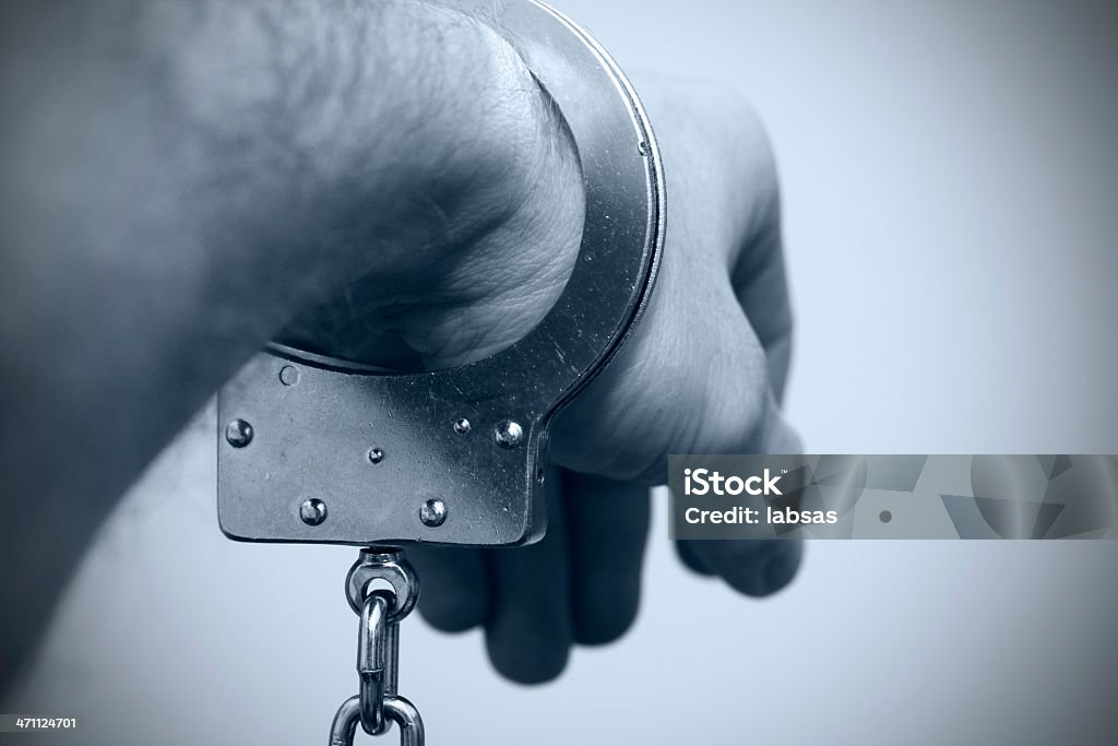 Mano con handcuff. Viraggio. Vignettatura. - Foto stock royalty-free di Acciaio